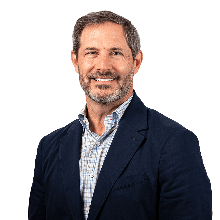 Smiling man in a blue blazer and plaid shirt.