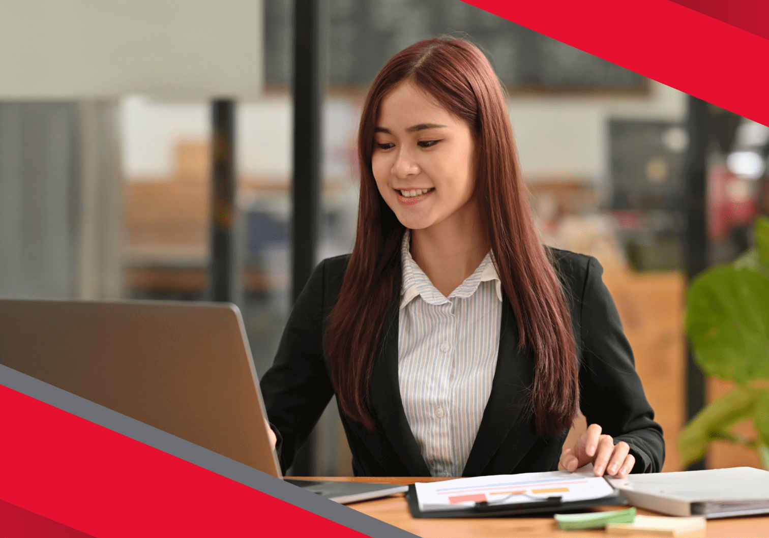 Smiling businesswoman working on laptop.